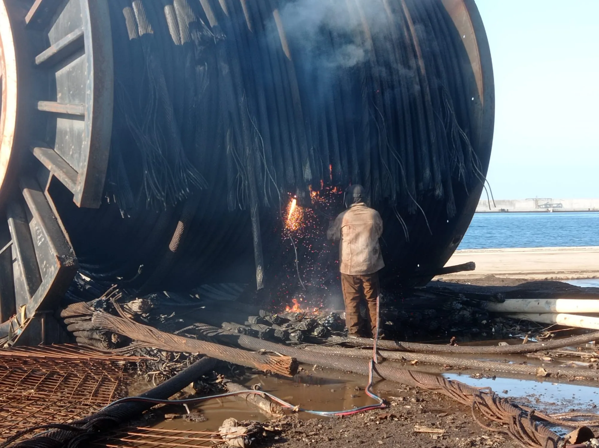 Operario realizando un corte en una gran pieza metálica